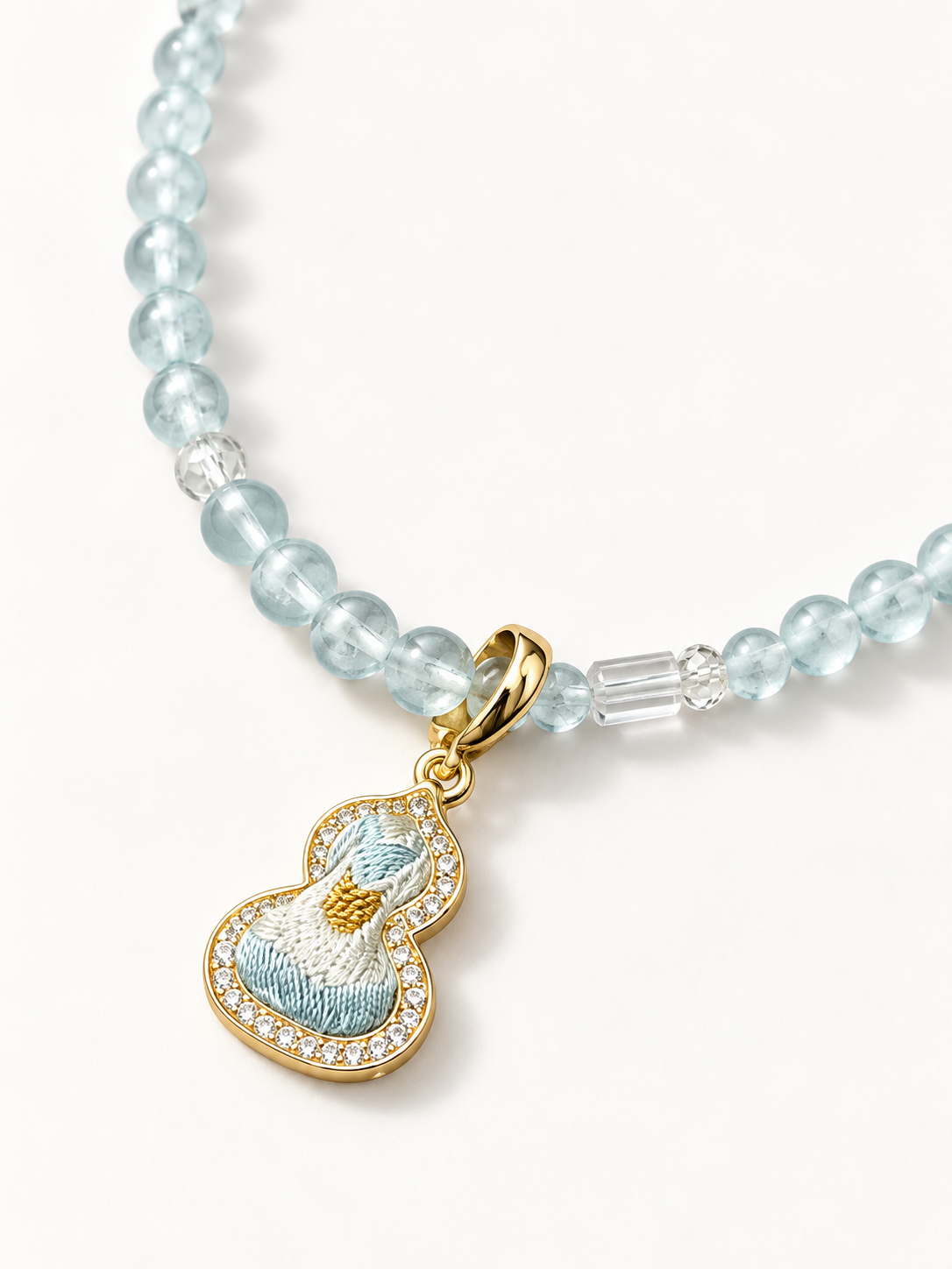 Close view of the Song brocade pendant and nearby blue, purple and clear beads