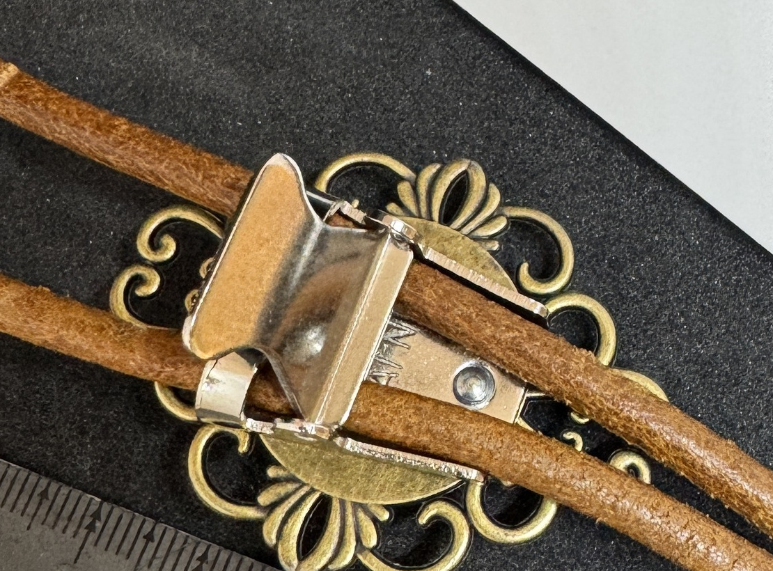 Actual rear view of the bolo tie slide mechanism and tan cord.