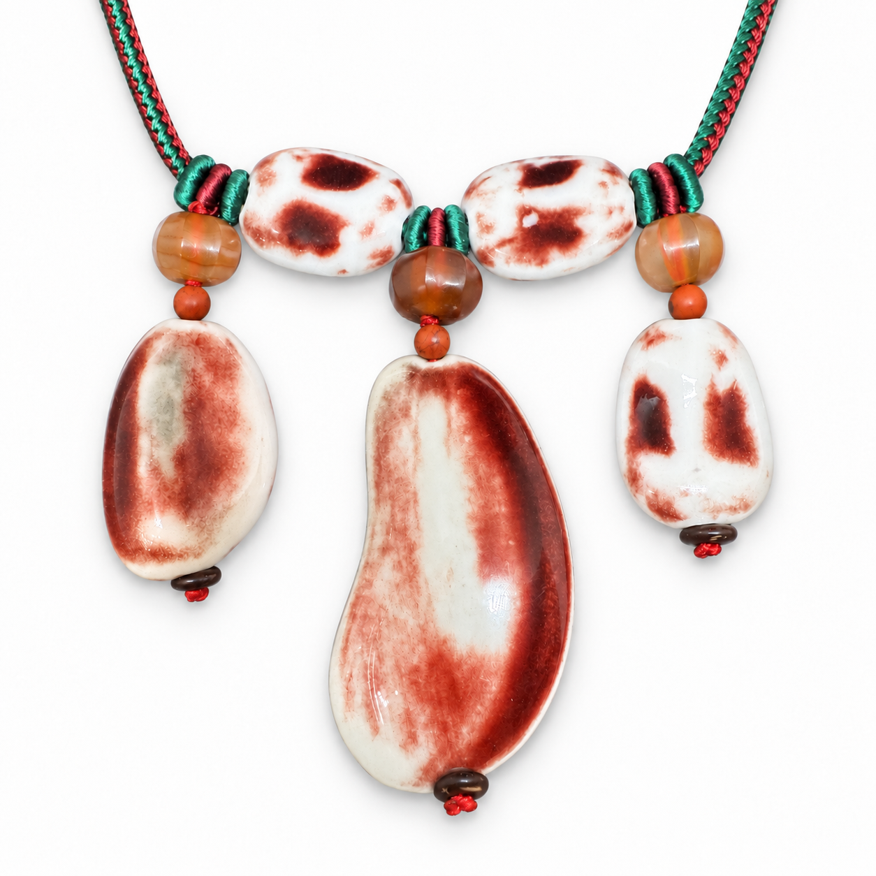 Upright detail of five red and white glazed ceramic pieces and accent beads.