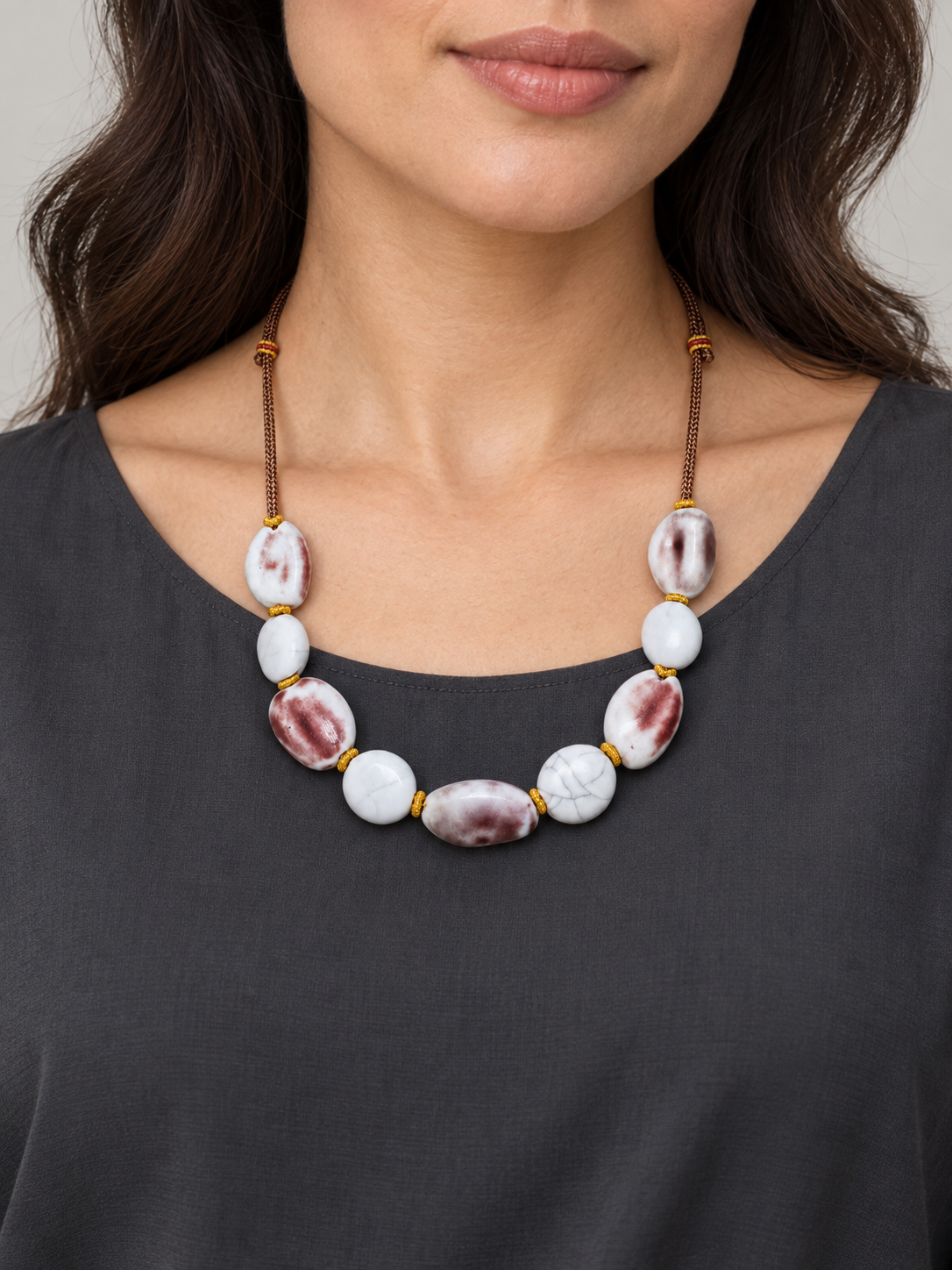 Maroon and white ceramic bead necklace worn with a charcoal top.