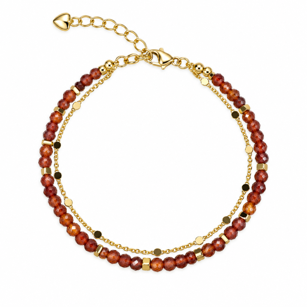 Ember-red faceted bead and gold-tone double-strand bracelet arranged on white.