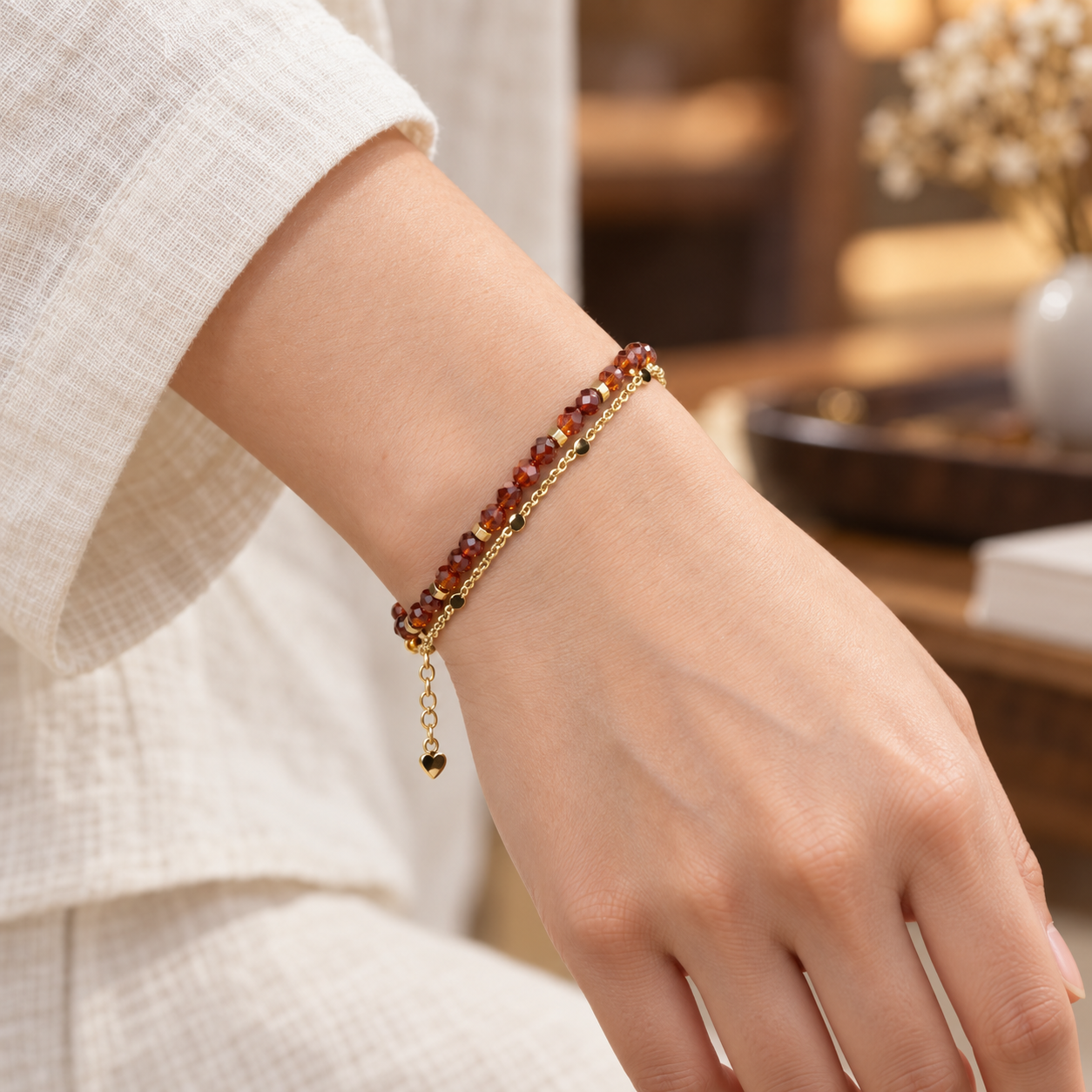 Close wrist view of the ember-red faceted bead double-strand bracelet.