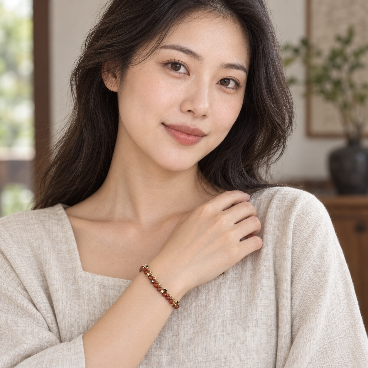 Adult model wearing the ember-red and gold-tone double-strand bracelet.