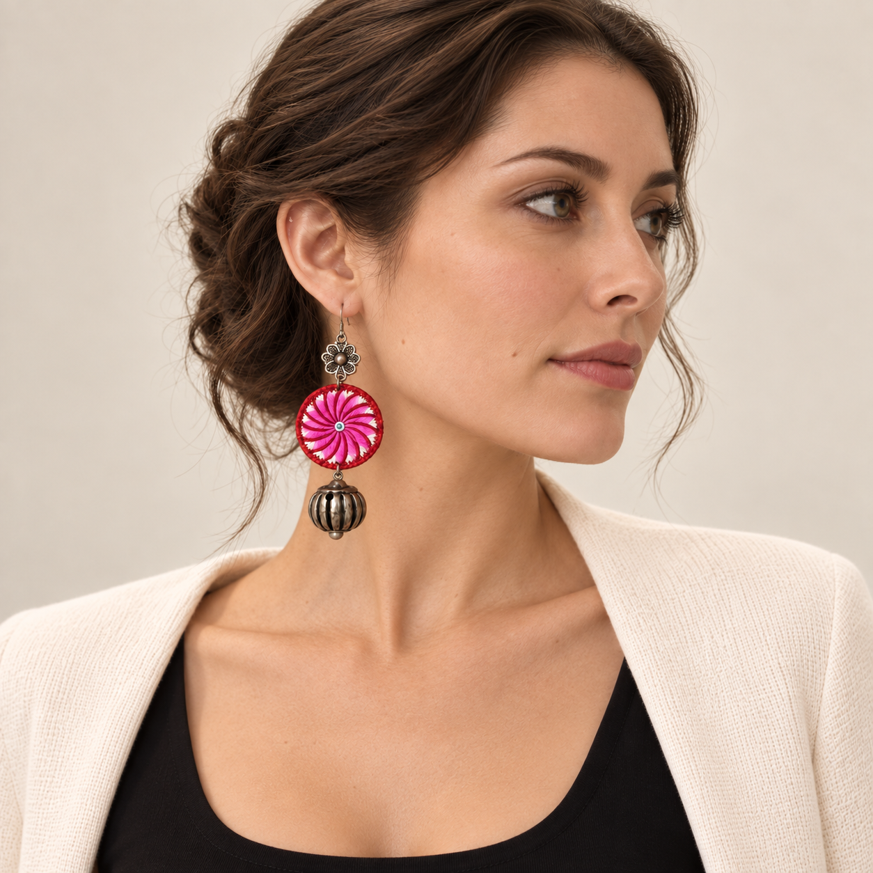 Full-face portrait of a model wearing the Pink Spiral Miao Embroidery Bell Earrings pair.